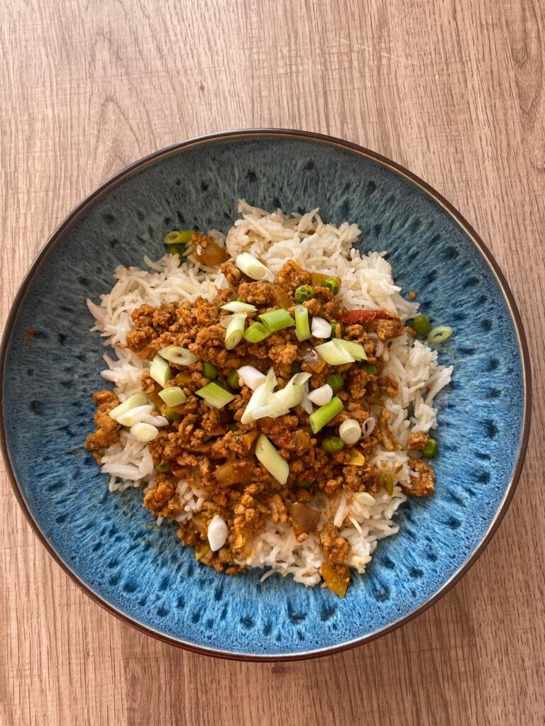 A blue bowl filled with turkey keema and rice.