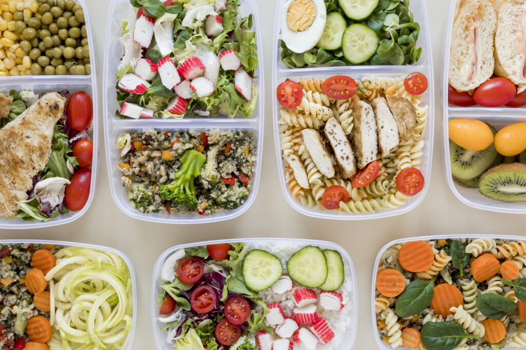 Several food storage containers filled with a variety of meals.
