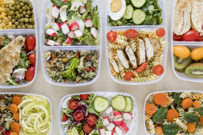 Several food storage containers filled with a variety of meals.
