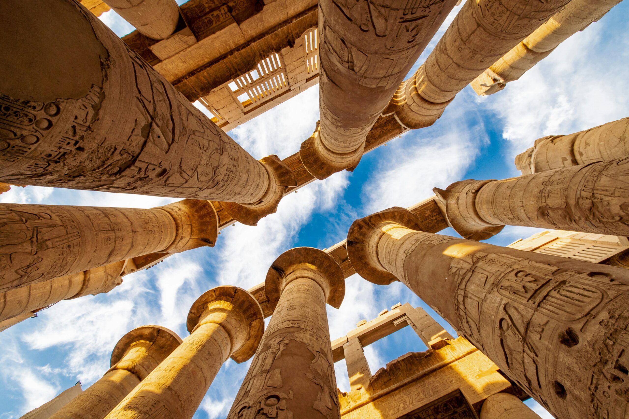 bottom view up to sky between Egyptian columns