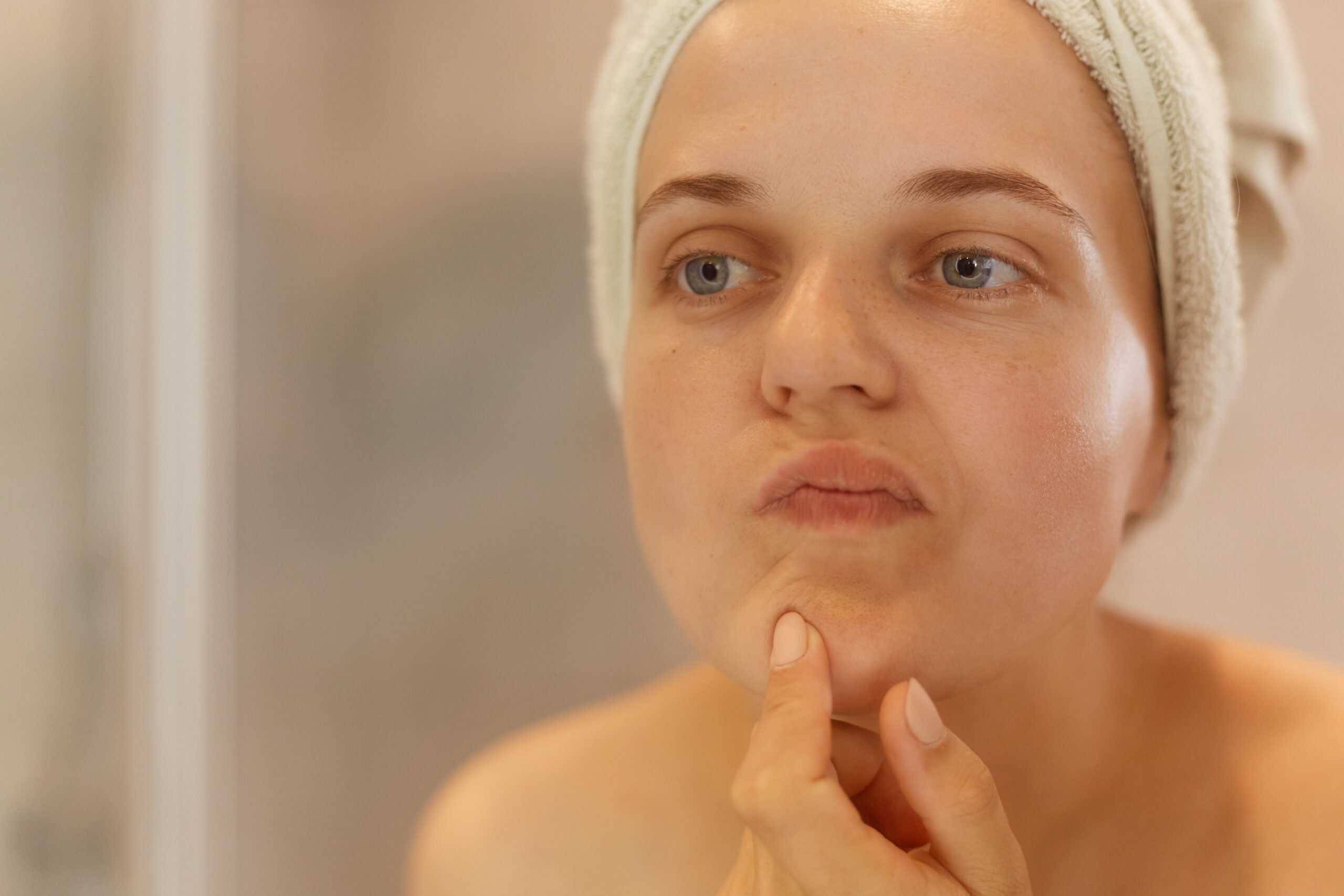 Woman checks her face in the mirror