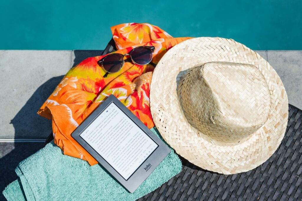 A kindle and sun hat by the pool on holiday