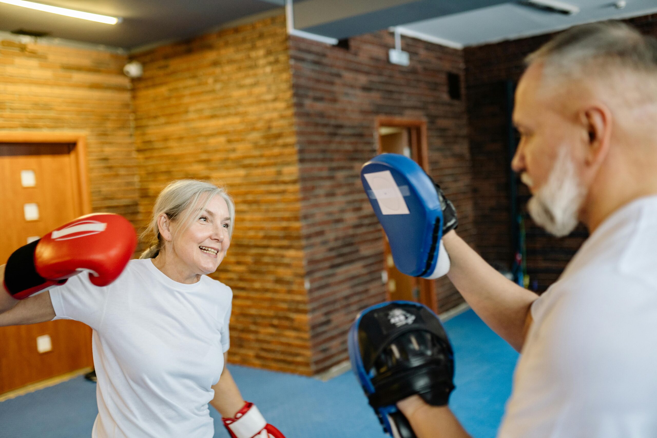 older to middle aged woman boxing with a man