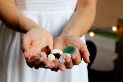 Woman holding a number of crystals in both hands cupped together.