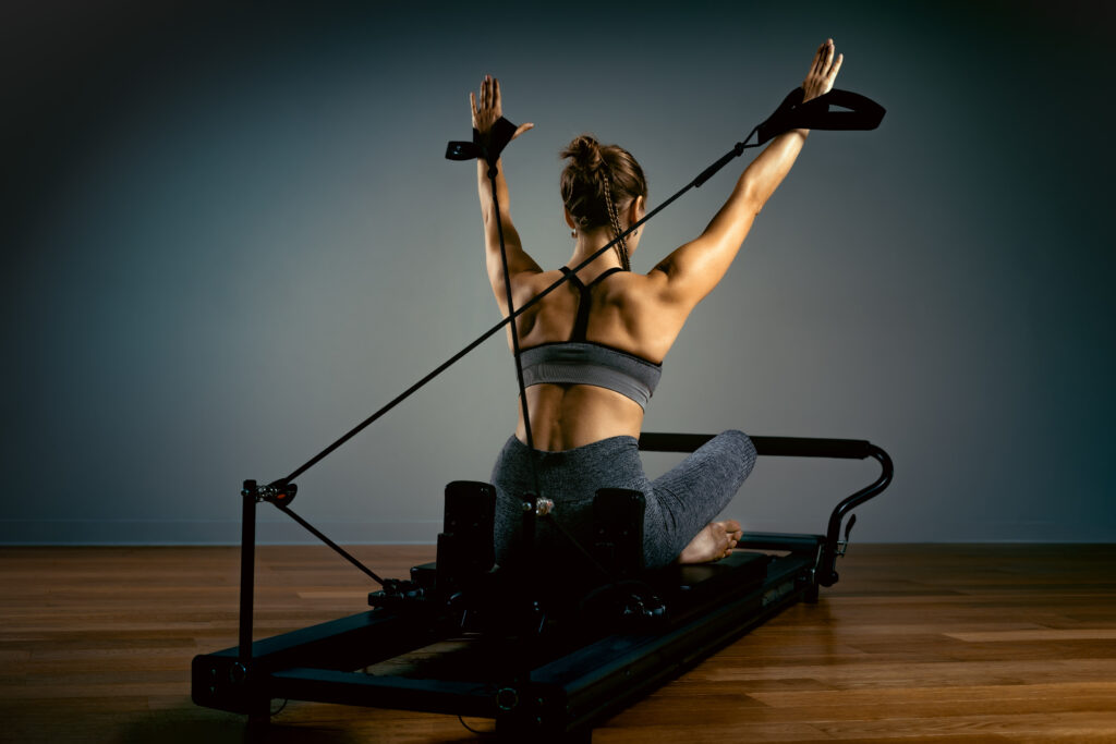 Woman doing Pilates on a reformer machine