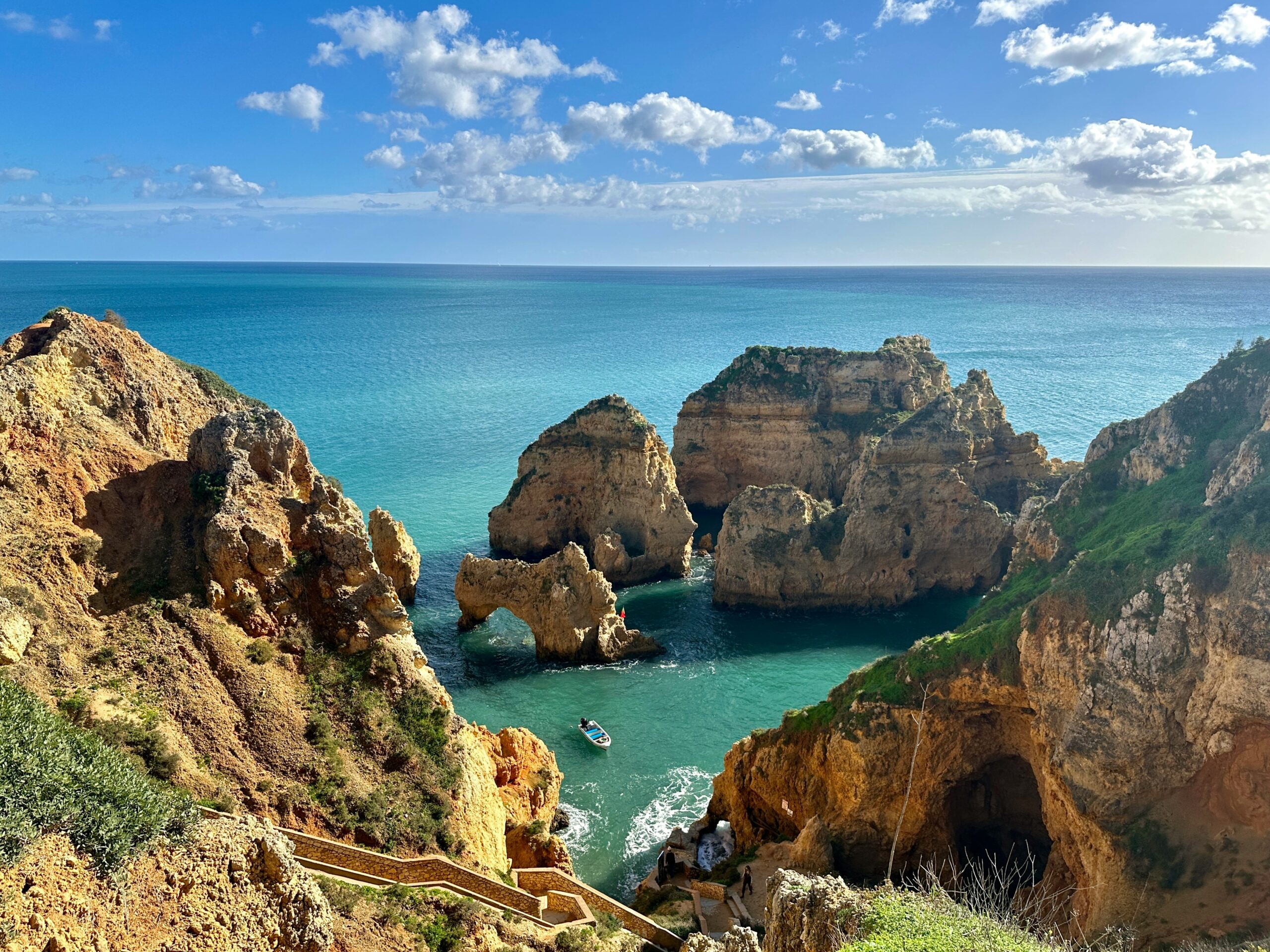 rocky waters in the algarve with a boat
