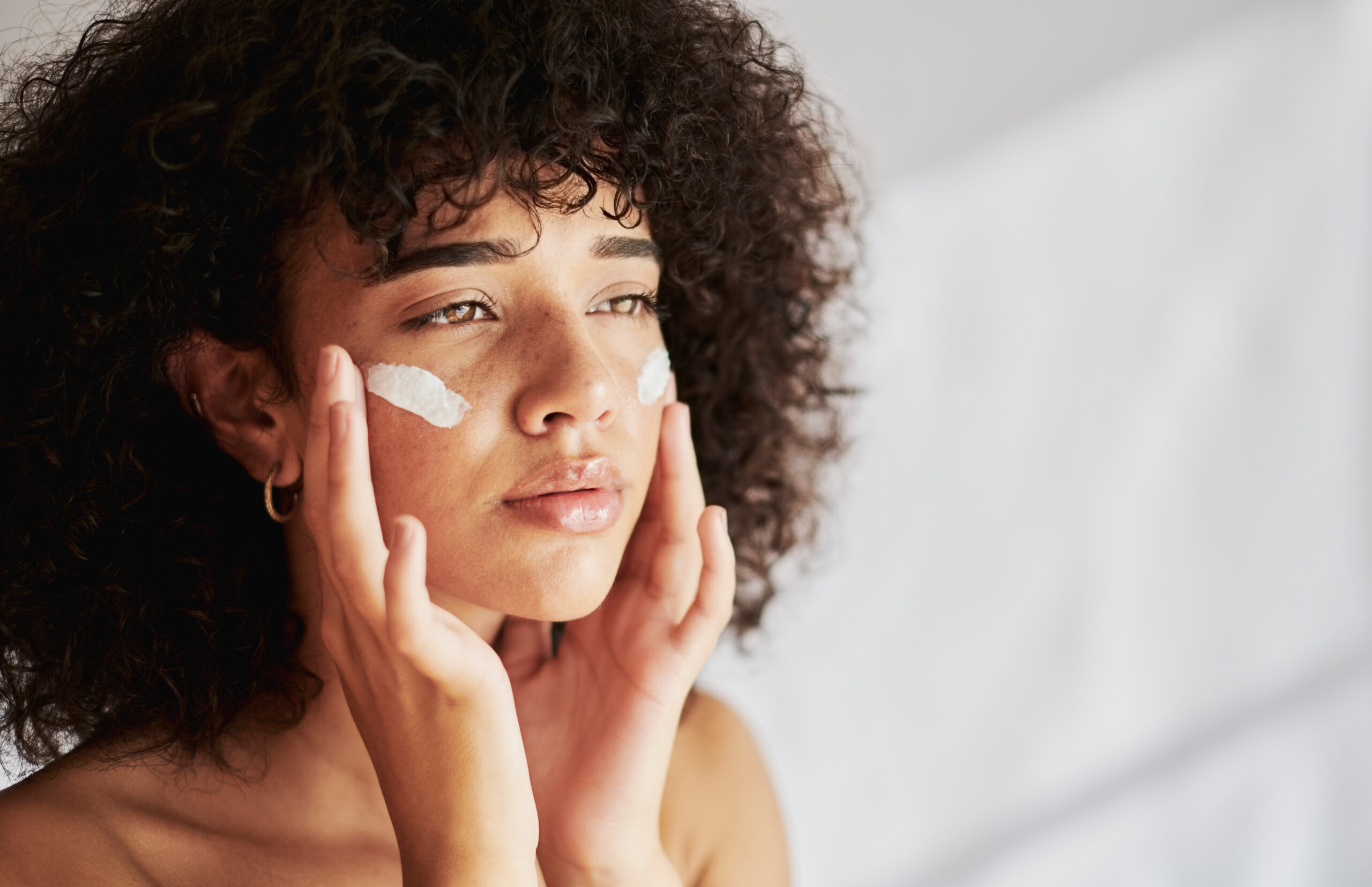 woman, beauty and skincare cream for dermatology, cosmetics and collagen product. Face of a wellness model in studio for skin glow, sunscreen and self care luxury facial cosmetic mockup