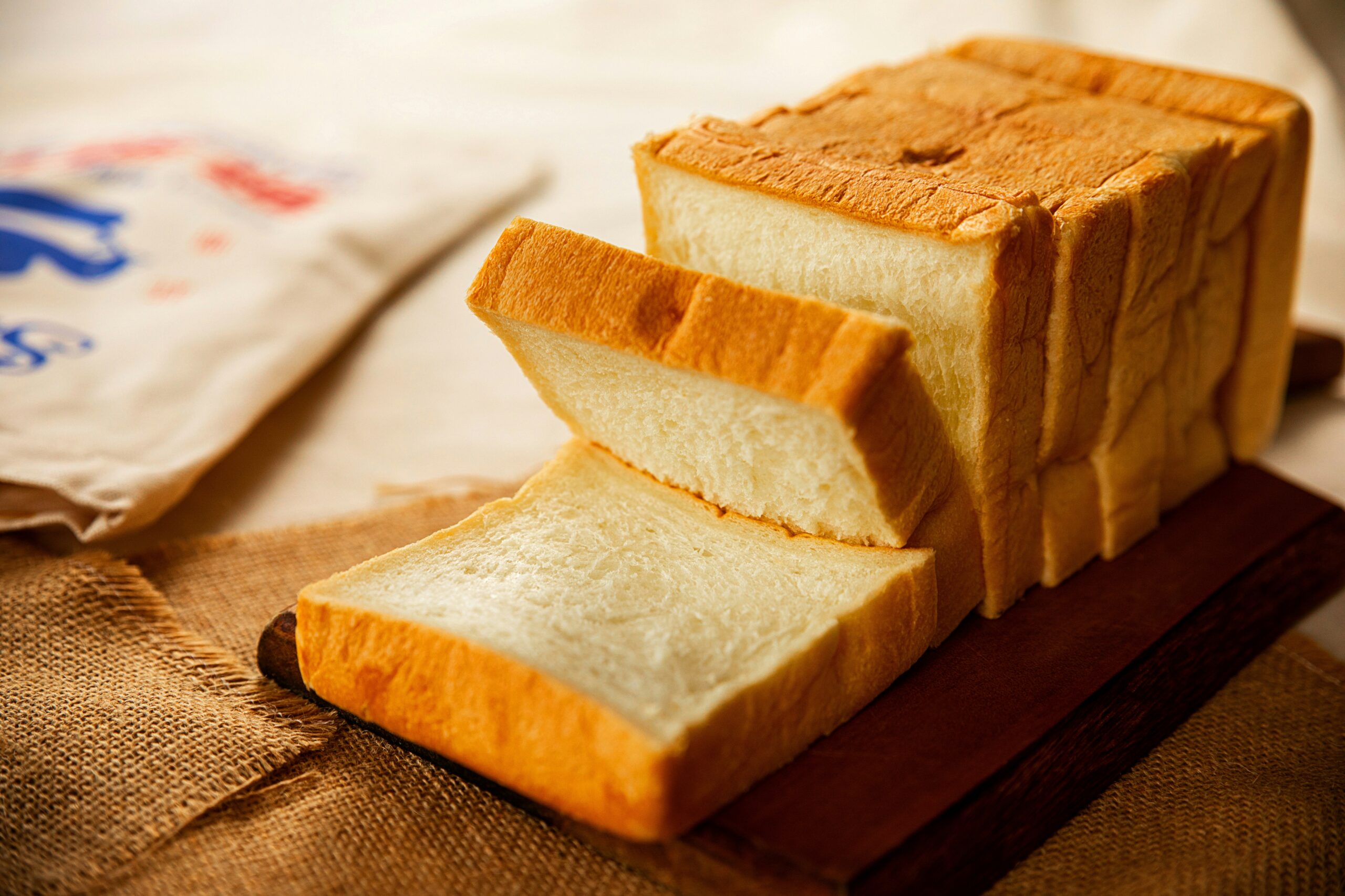 wooden table with loaf of bread sliced on top ultra-processed food (UPFs)