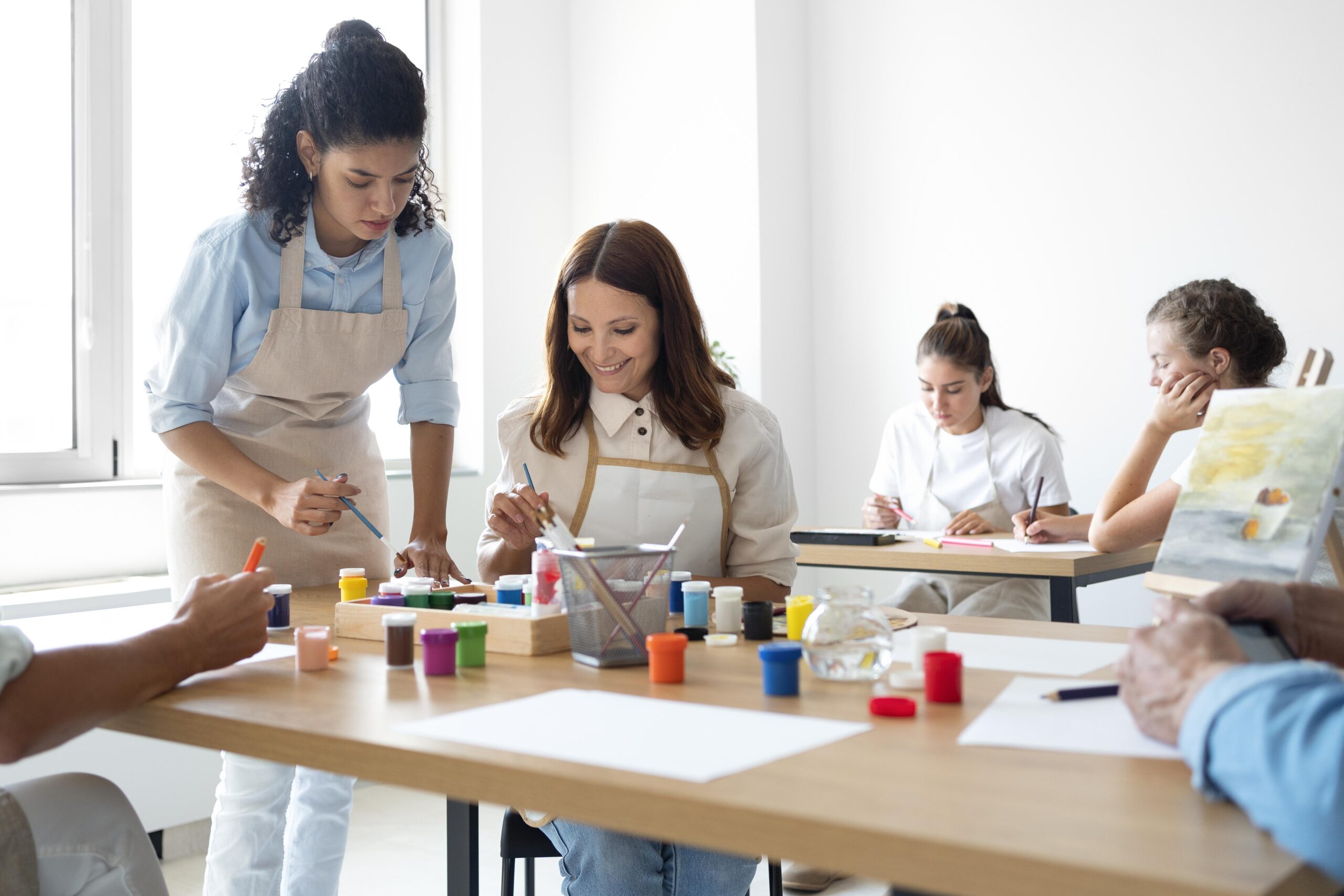 Woman smiles as she participates in an art clasa