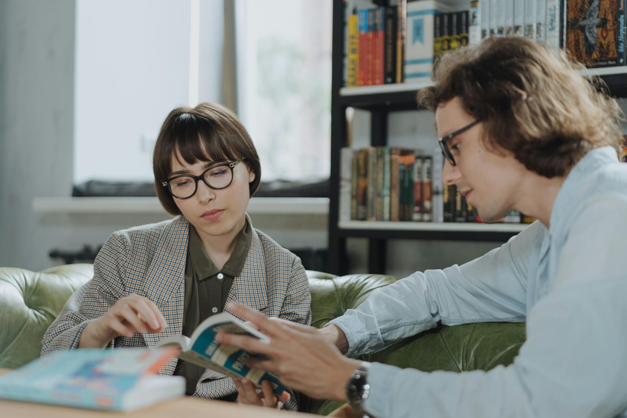 a man and a woman looking at a book discussing the book