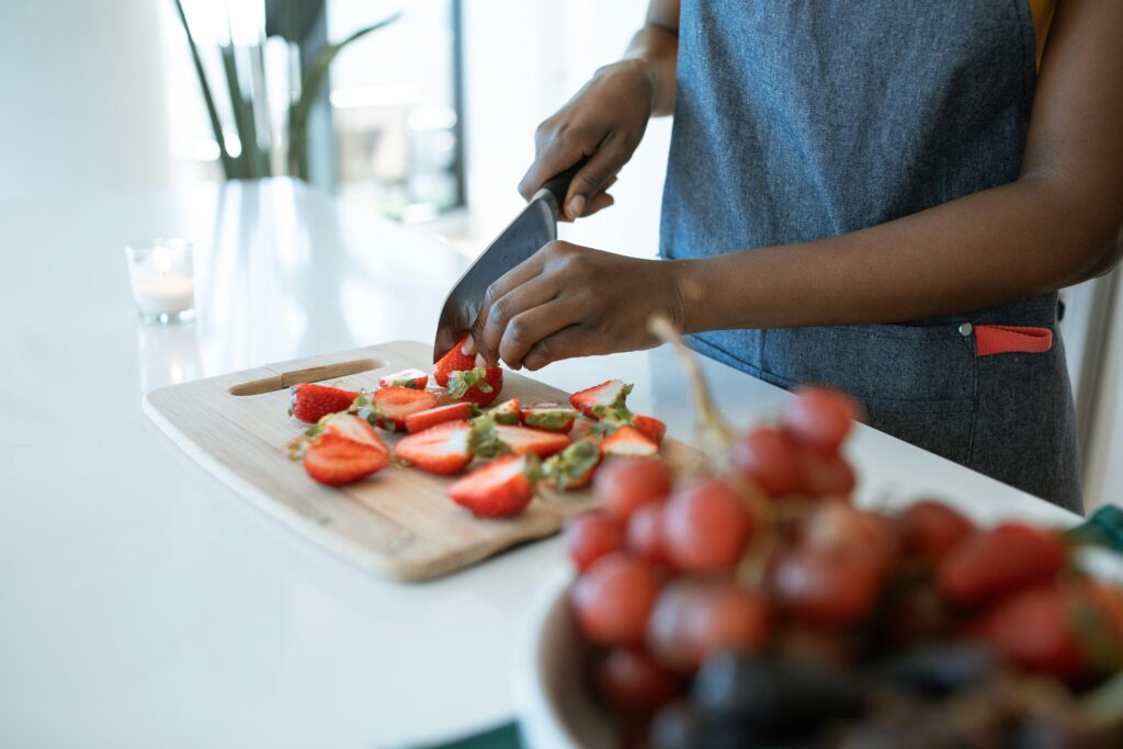 A woman cuts strawberries in her kitchen