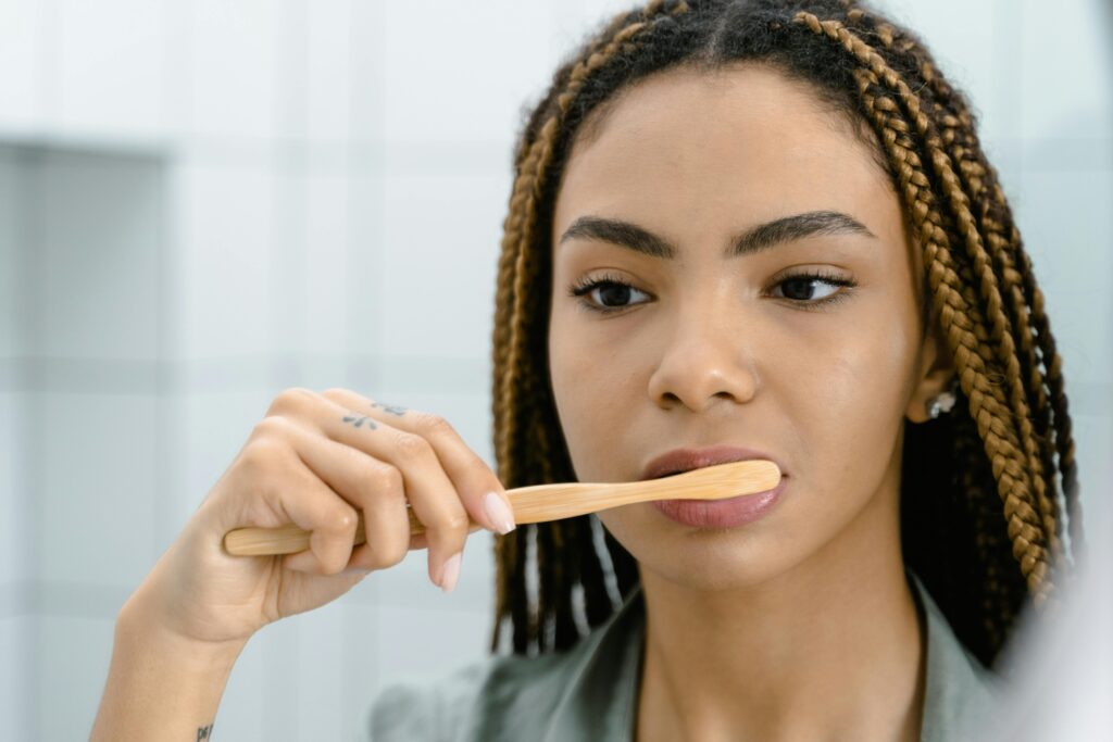A woman brushes her teeth in the mirror