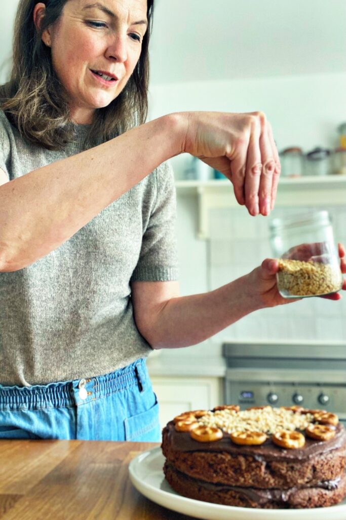 Emily Kerrigan sprinkles topping on a cake
