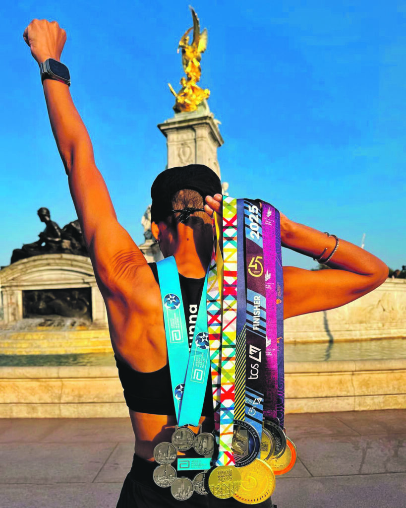 Adele Roberts holding her seven marathon medals