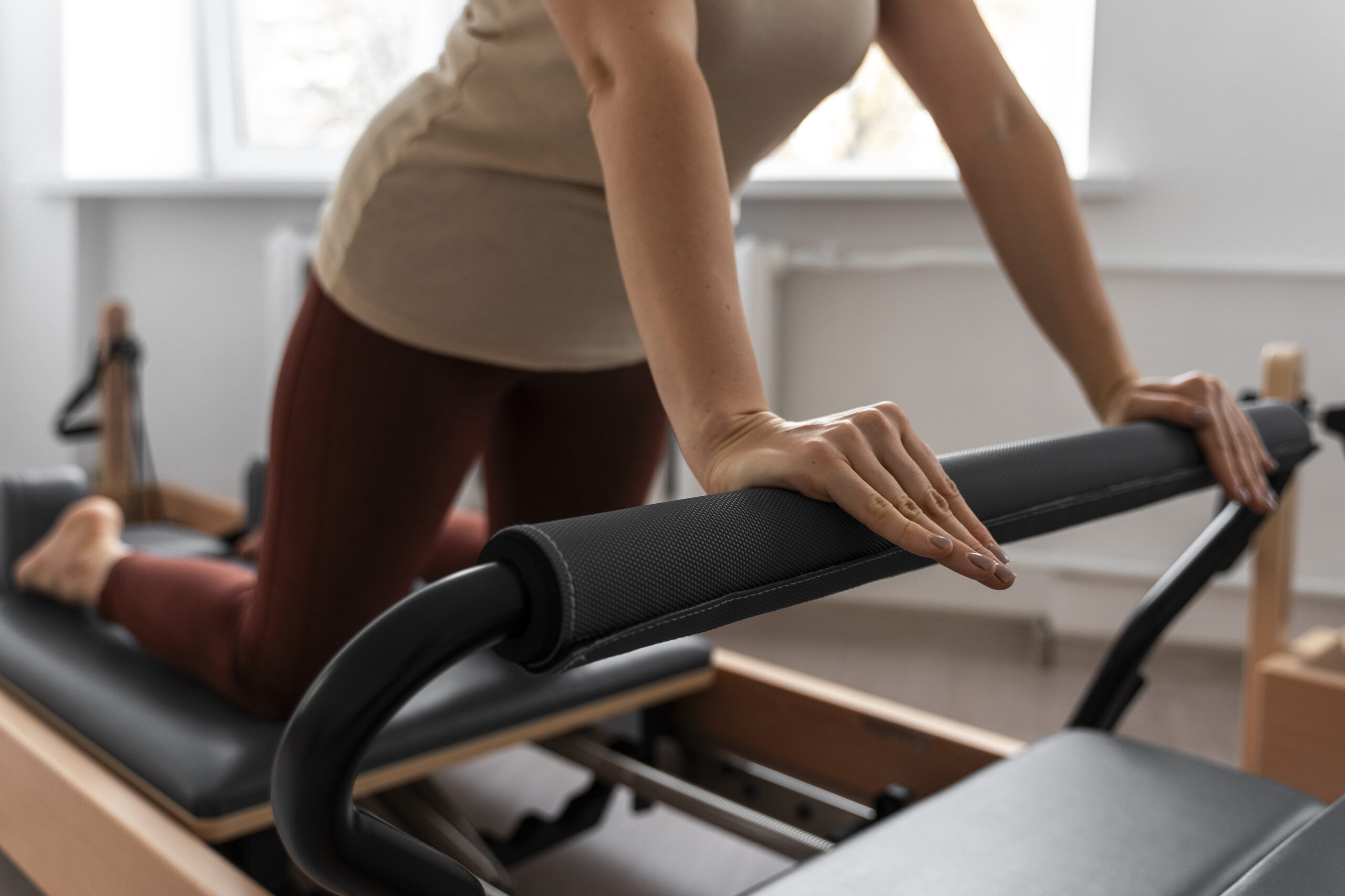 Woman uses a reformer Pilates machine at home