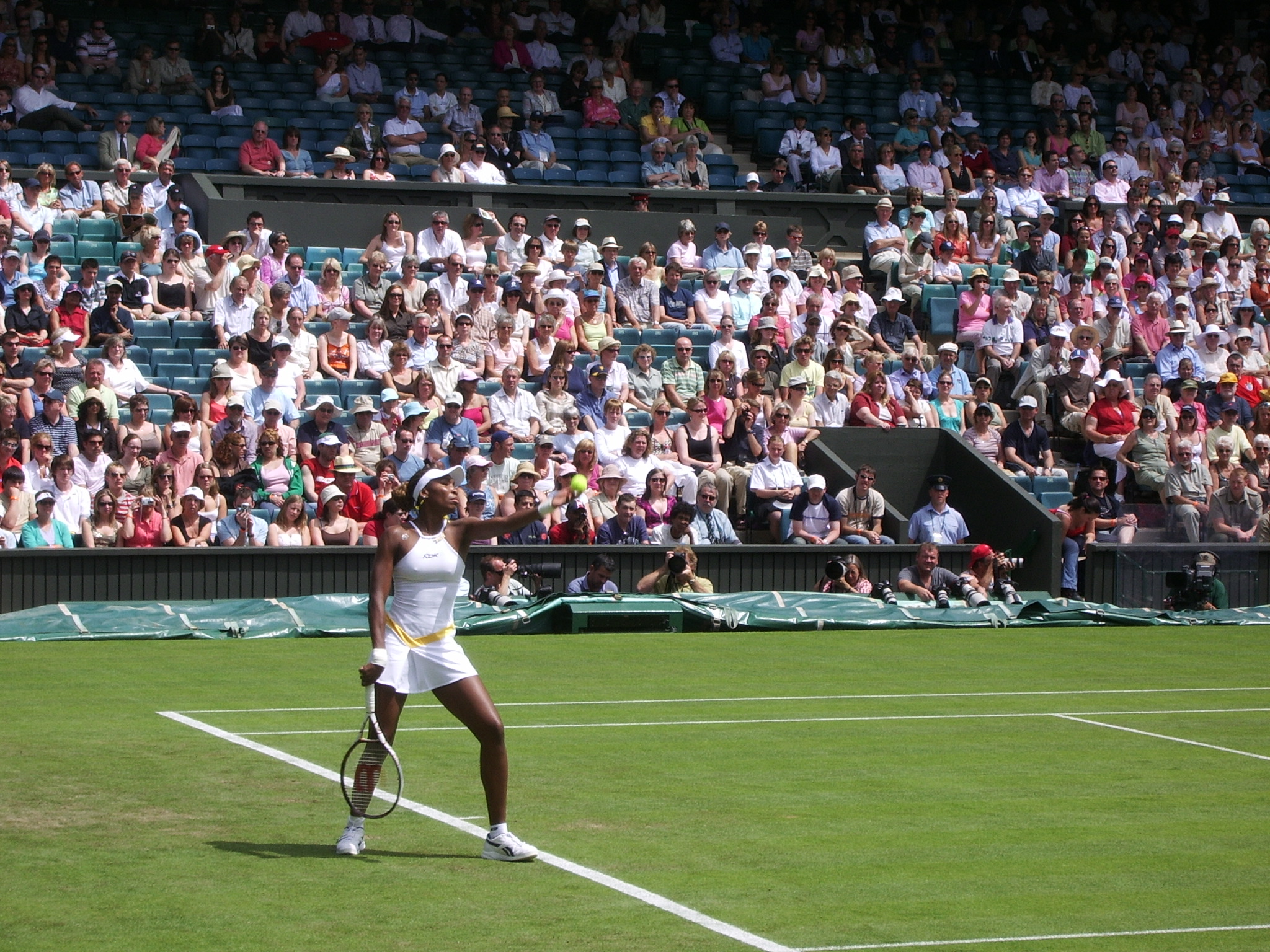Venus Williams playing tennis throwing ball at Wimbledon crowd