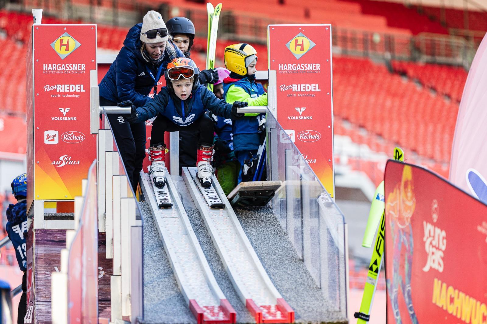 Mani Cooper coaching a child at ski jump