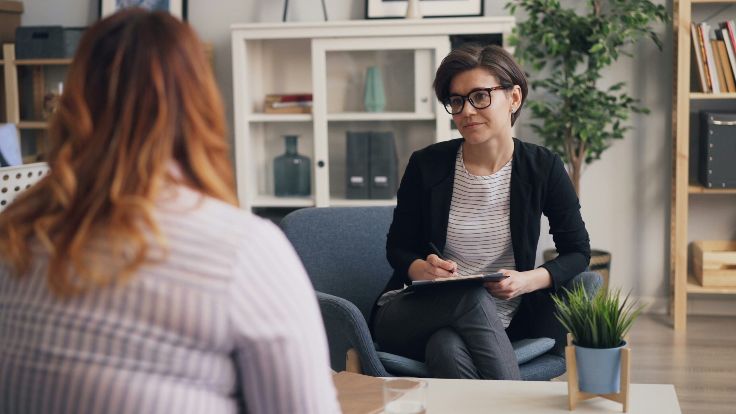 woman in chair talking to another woman