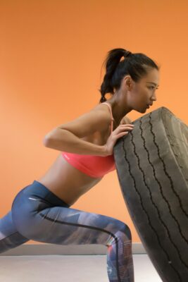 woman in workout clothes pushing tire for exercise tire slip and slap