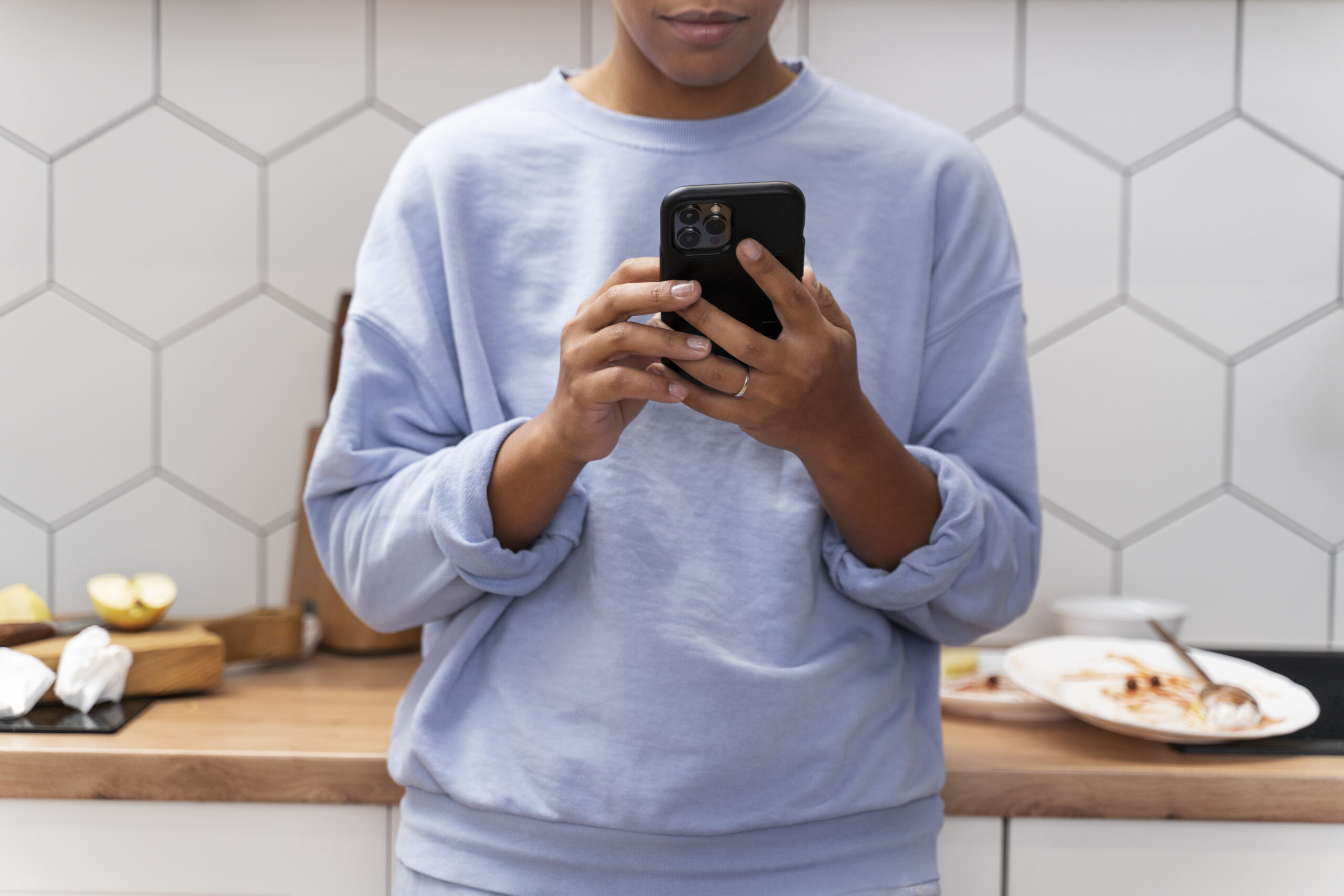 Woman uses phone in kitchen