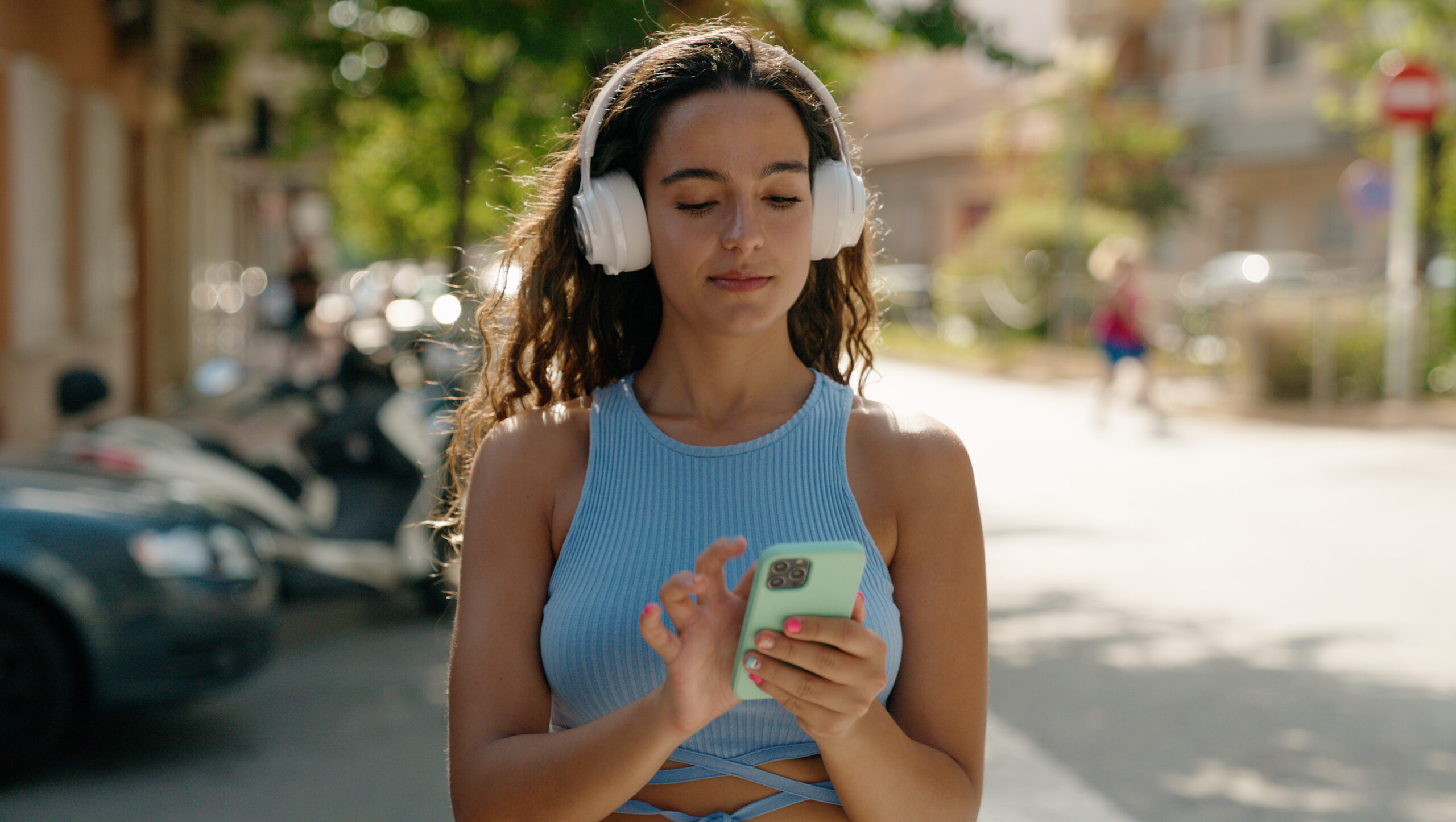 Young woman watching video on smartphone at street