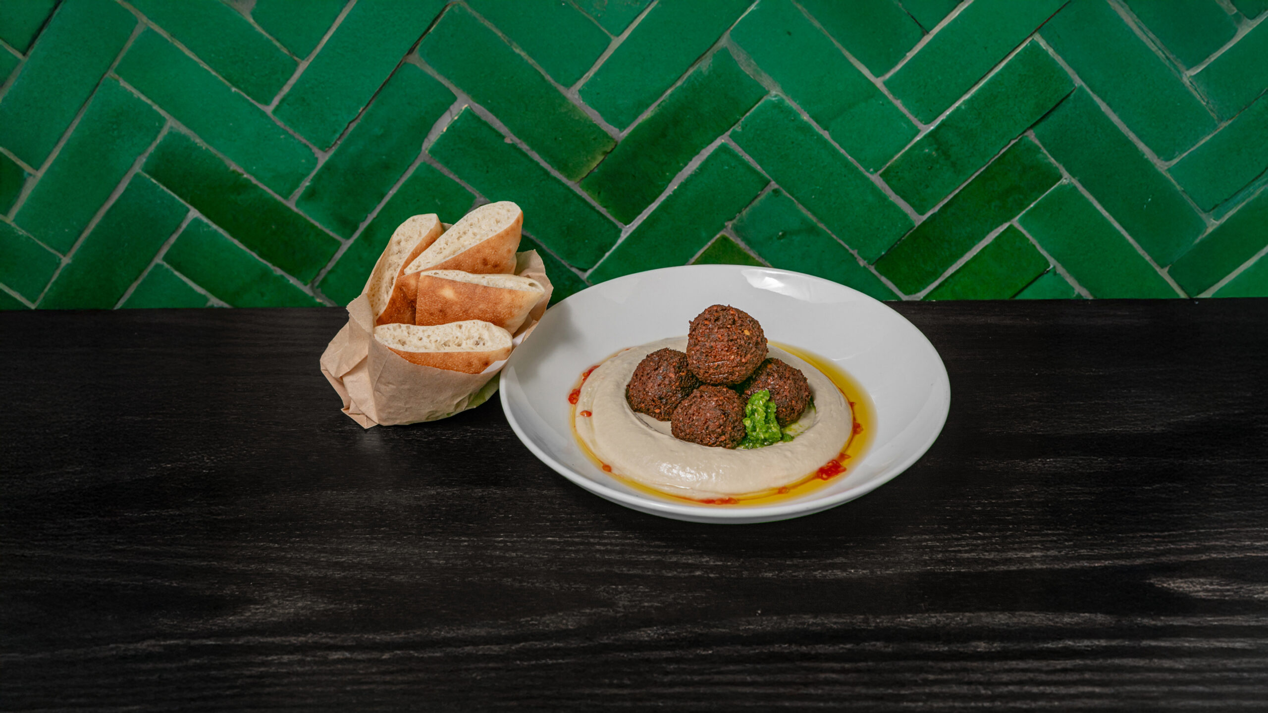table with plate of hummus and falafel with bread