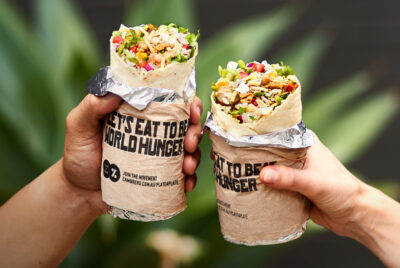 Two people holding burrito 