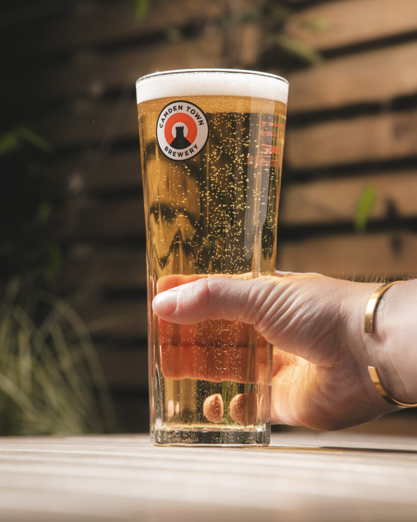 hand holding a pint of Camden Hells lger