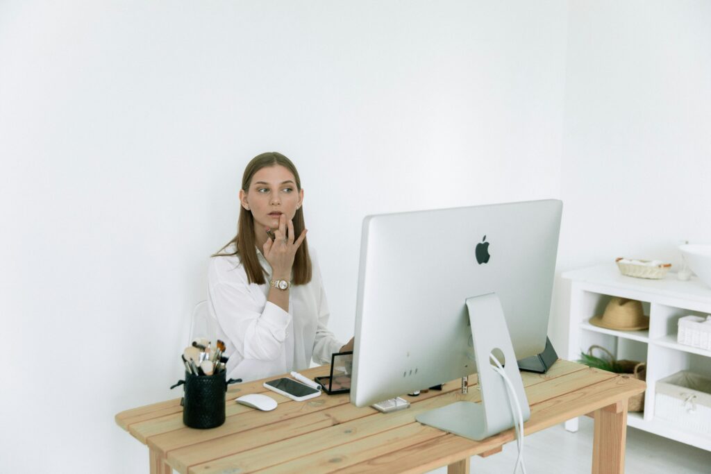 Woman doing make up at desk 