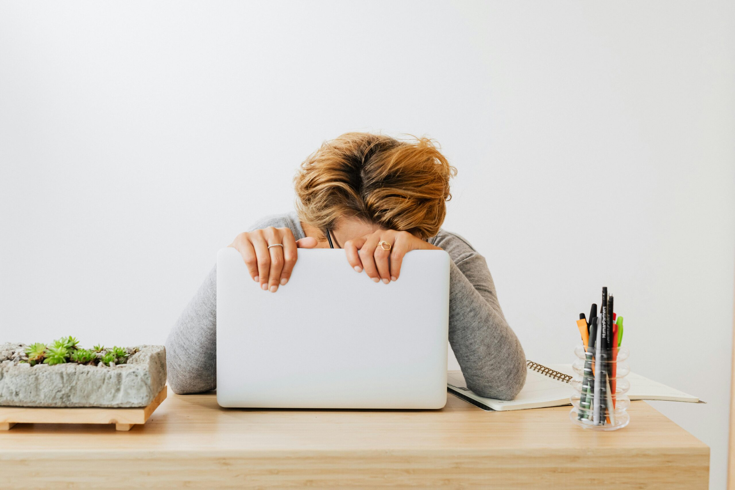 exasperated woman with head on laptop