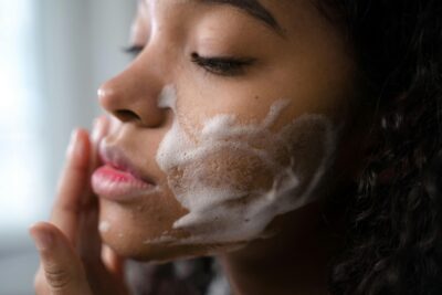 Woman cleansing skin with foaming face wash
