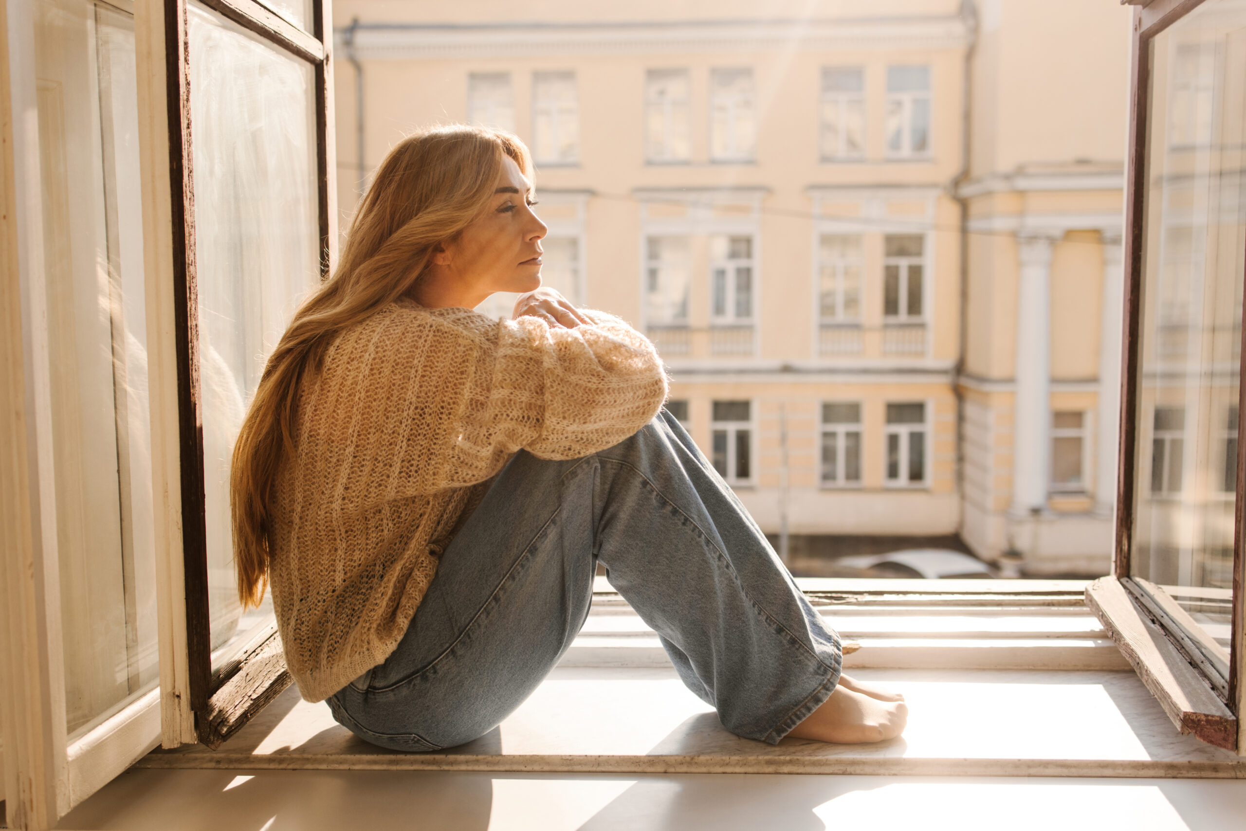 Woman sitting on windowsill