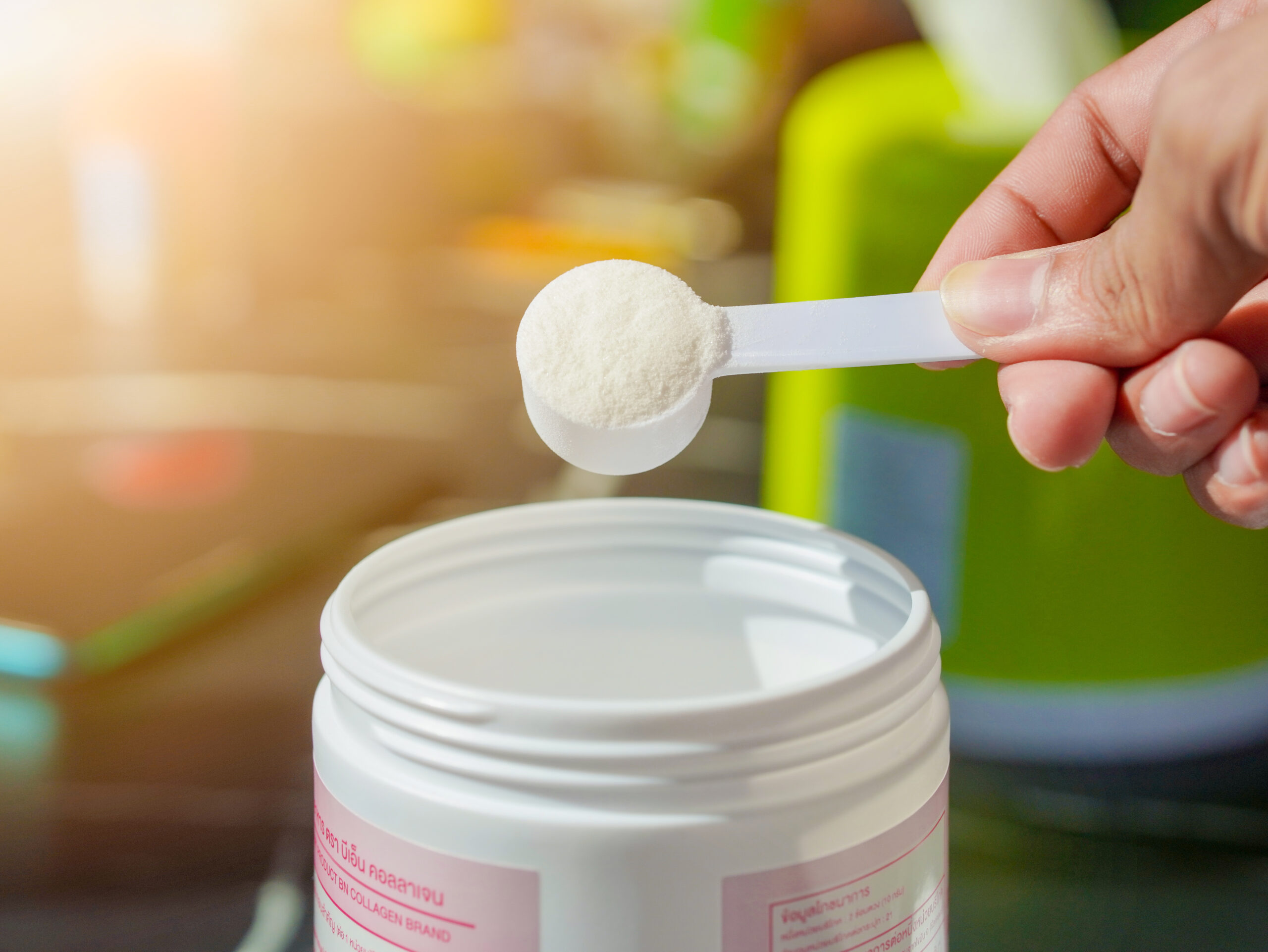 Lifestyle Health care. Hands of a person scooping collagen powder from a jar with a scoop. Collagen, which contains vitamins, helps nourish, anti age and restore the body's deterioration.