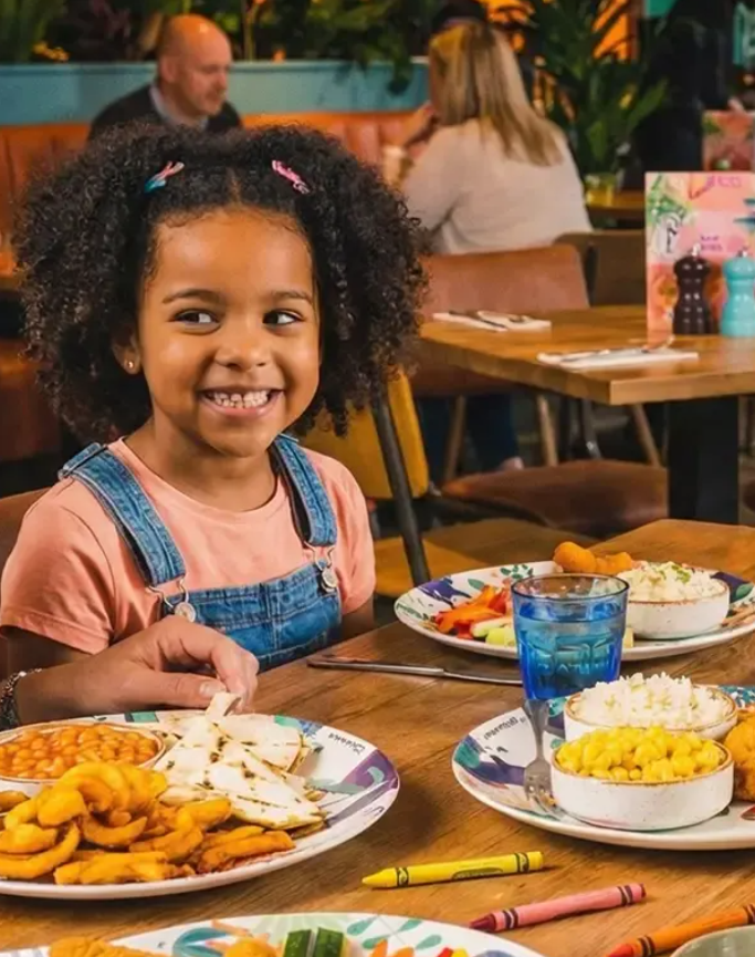 Girl smiling as she eats at Las Iguanas