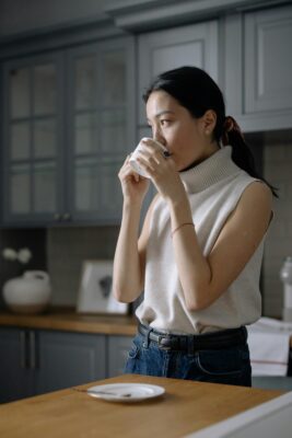 Woman drinking coffee in kitchen
