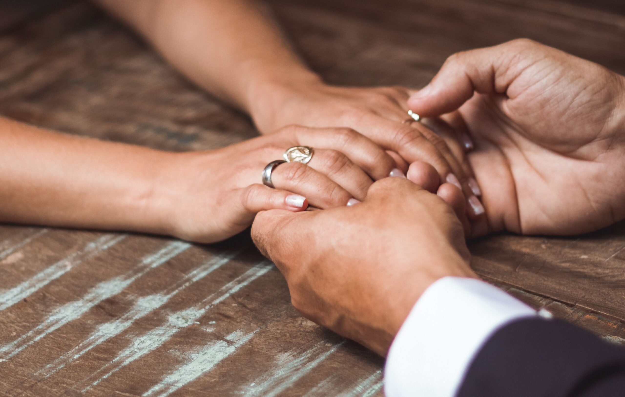 Couple holding hands over table 