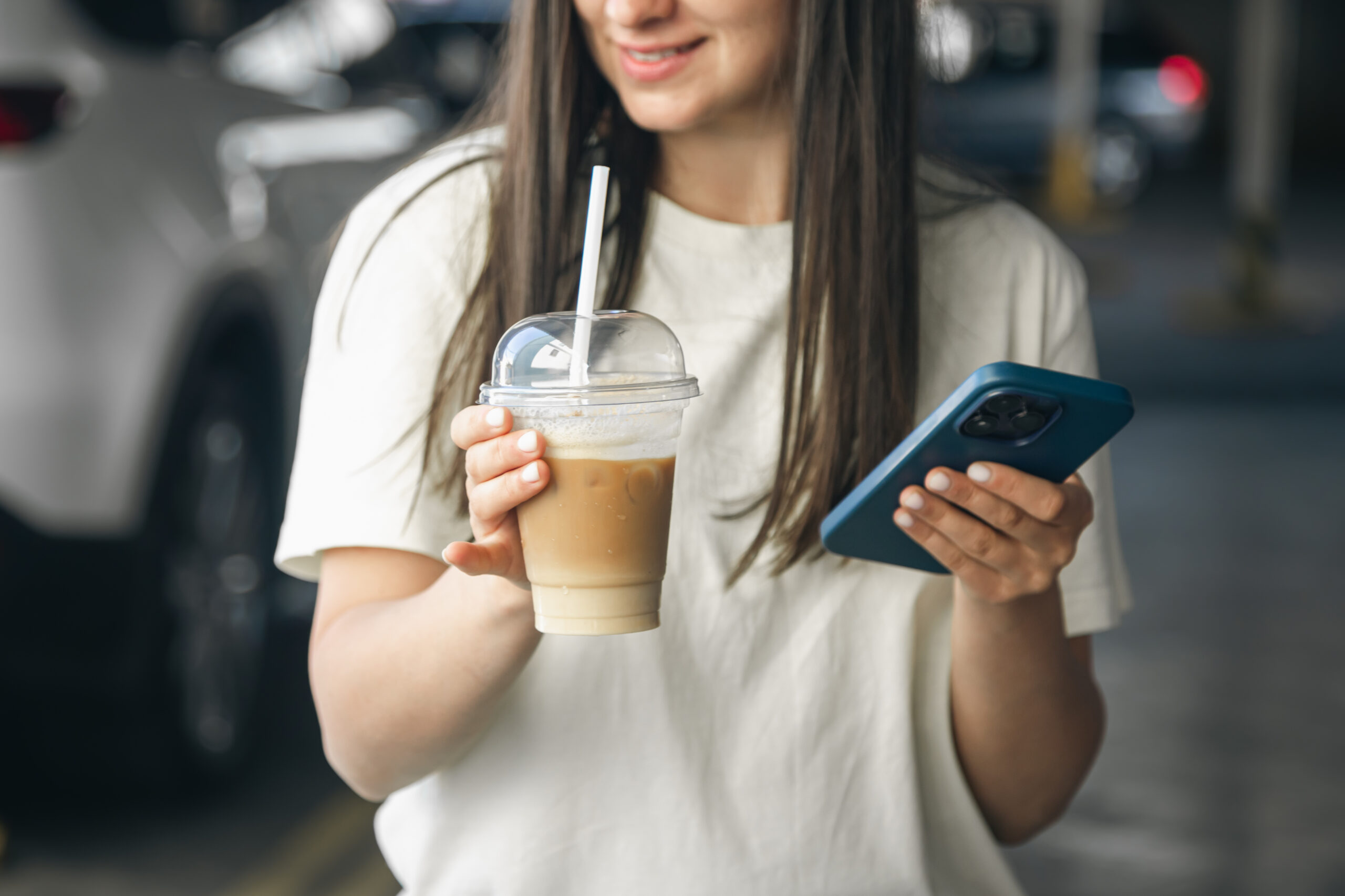 Woman drinks a takeaway iced latte