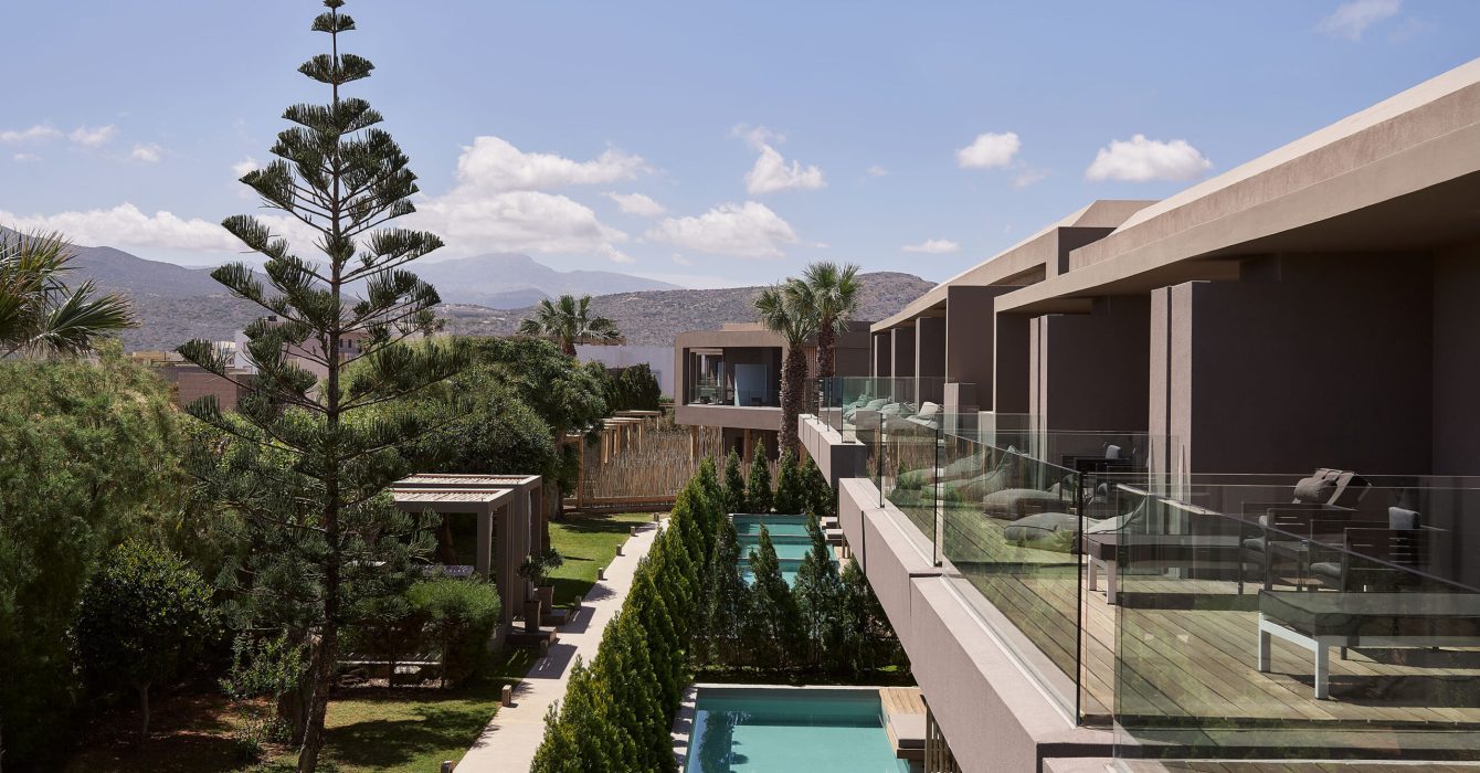 Hotel exterior with manicured lawn and pools