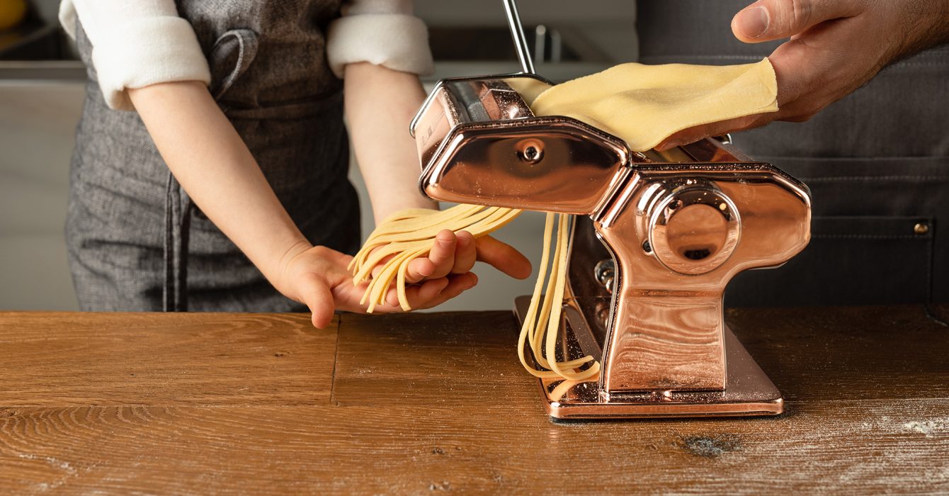 Hands working a pasta making device