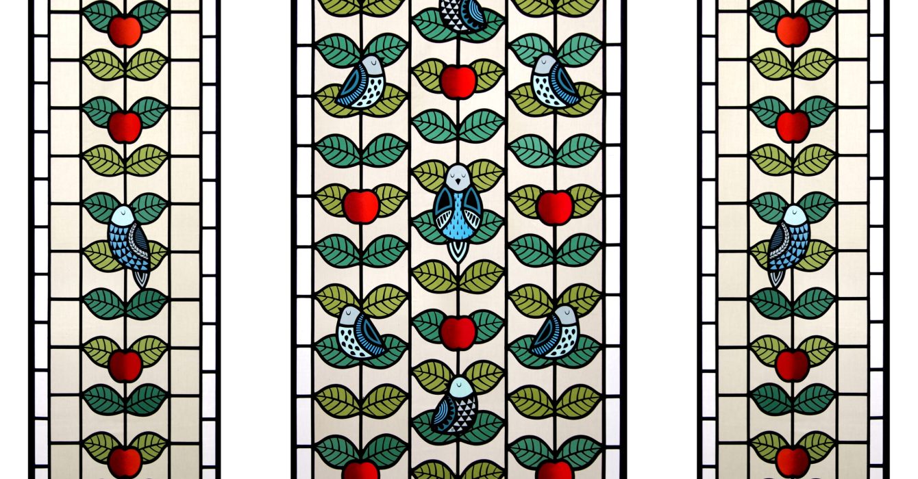 A stained glass creation of birds and apples by artist Flora Jamieson.