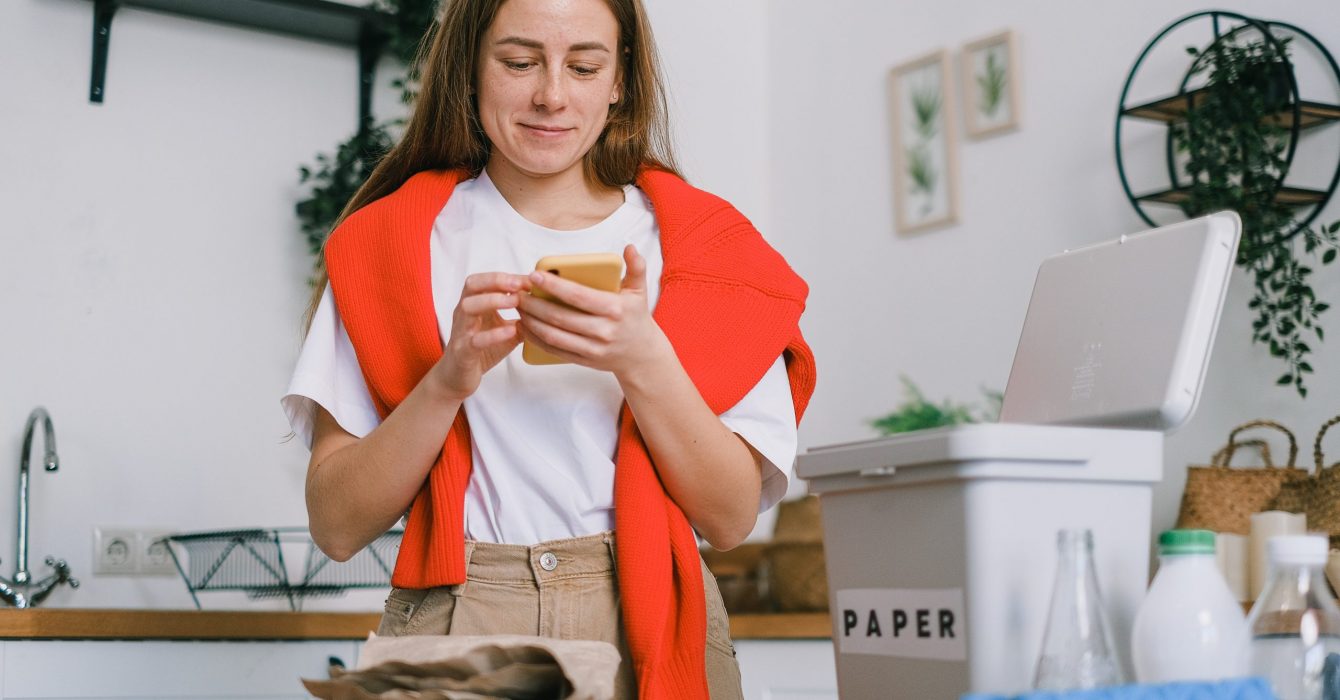 A woman uses a smart phone to run her eco friendly home.