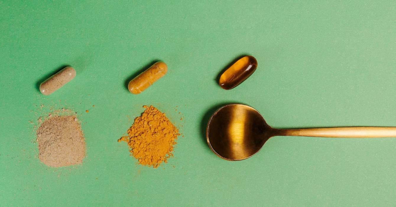 A spoon with different supplements and crushed powders