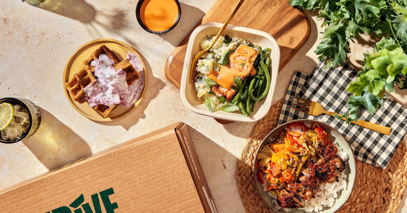 Flat lay of prepped meals in boxes with a cardboard box labelled Frive