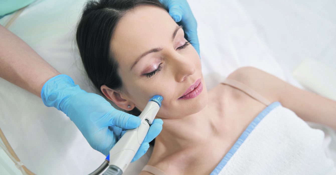 A young woman receiving a HydraFacial, a new non-invasive skincare treatment.