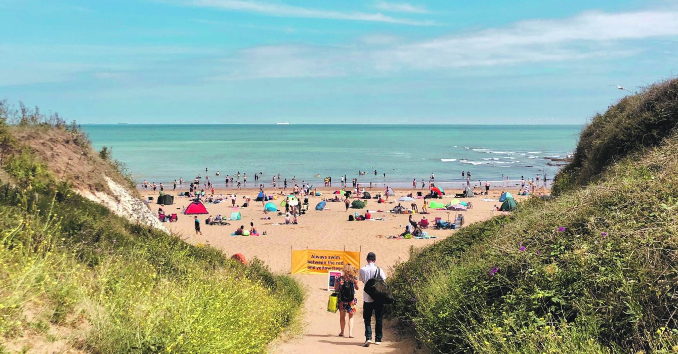 View of the beach and horizon over water. People enjoying a sunny day in Autumn. Image captured 11/17/2022