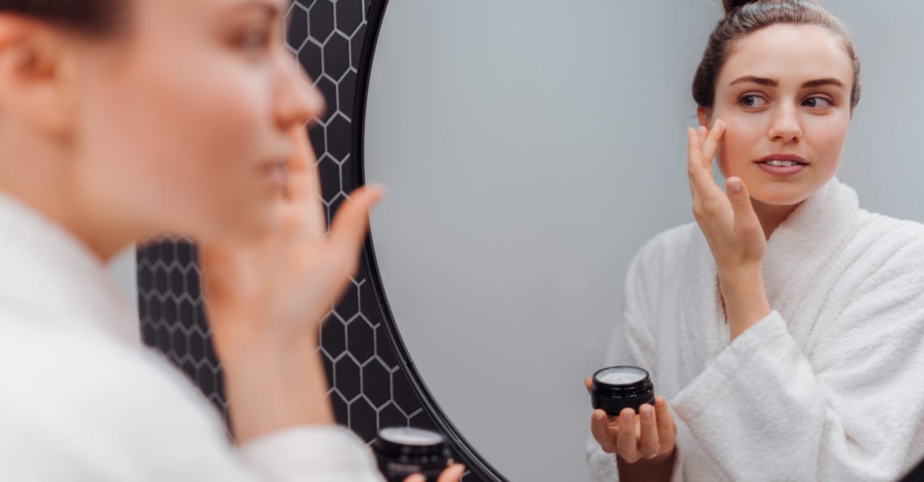 Young woman in bathrobe, concept of skincare routine.