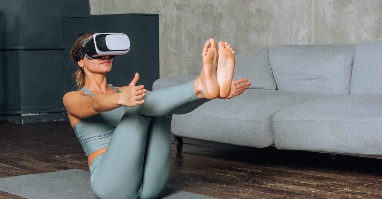 young beautiful woman goes in for sports in virtual reality using VR glasses