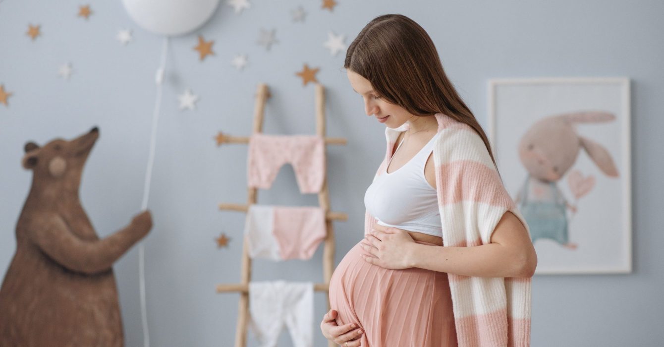 A young pregnant woman standing in her plastic free nursery.