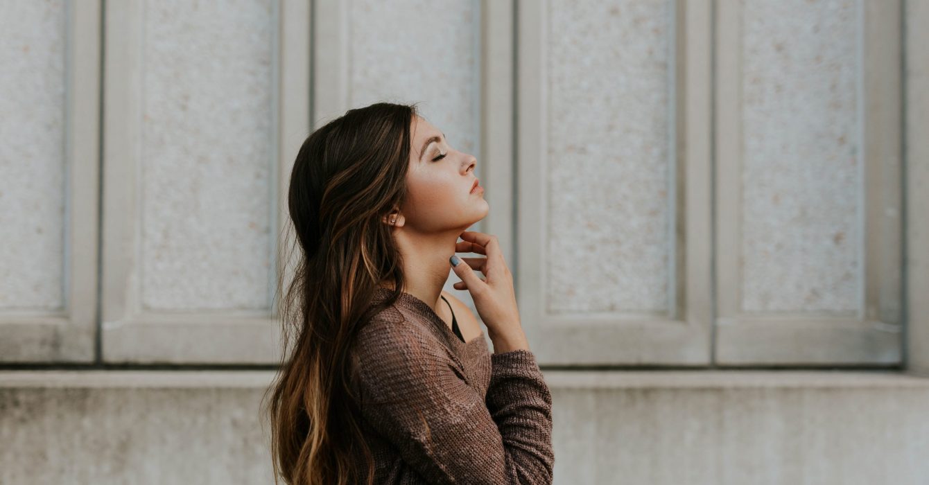 A woman in profile focuses on breathing.