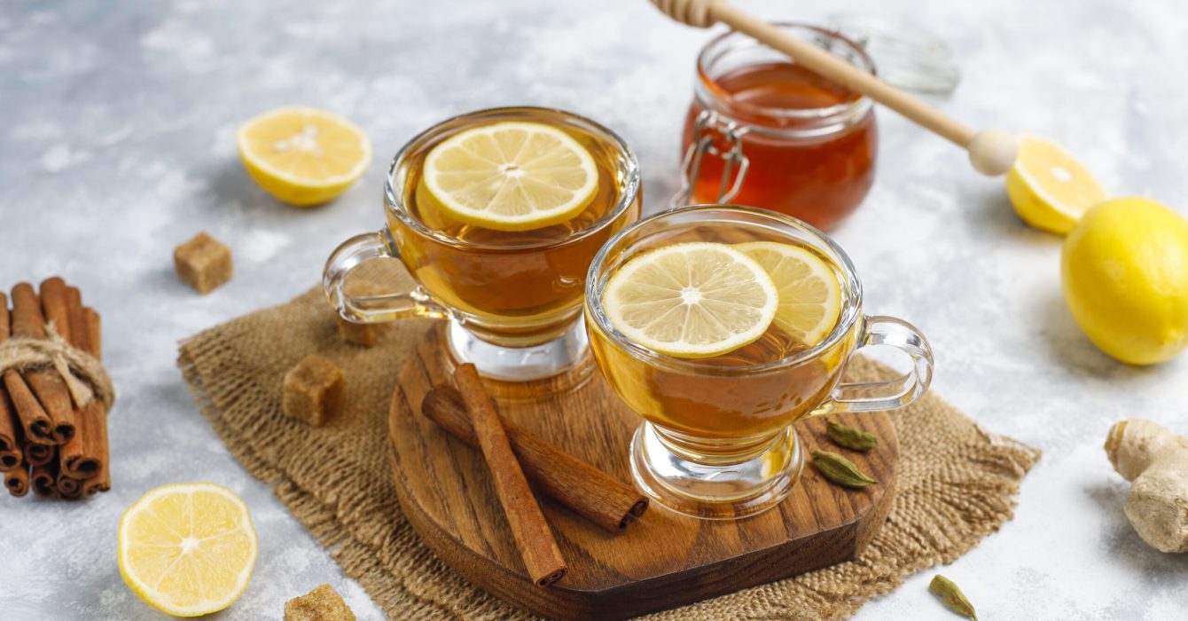 A cup of tea,brown sugar,honey and lemon on concrete  background